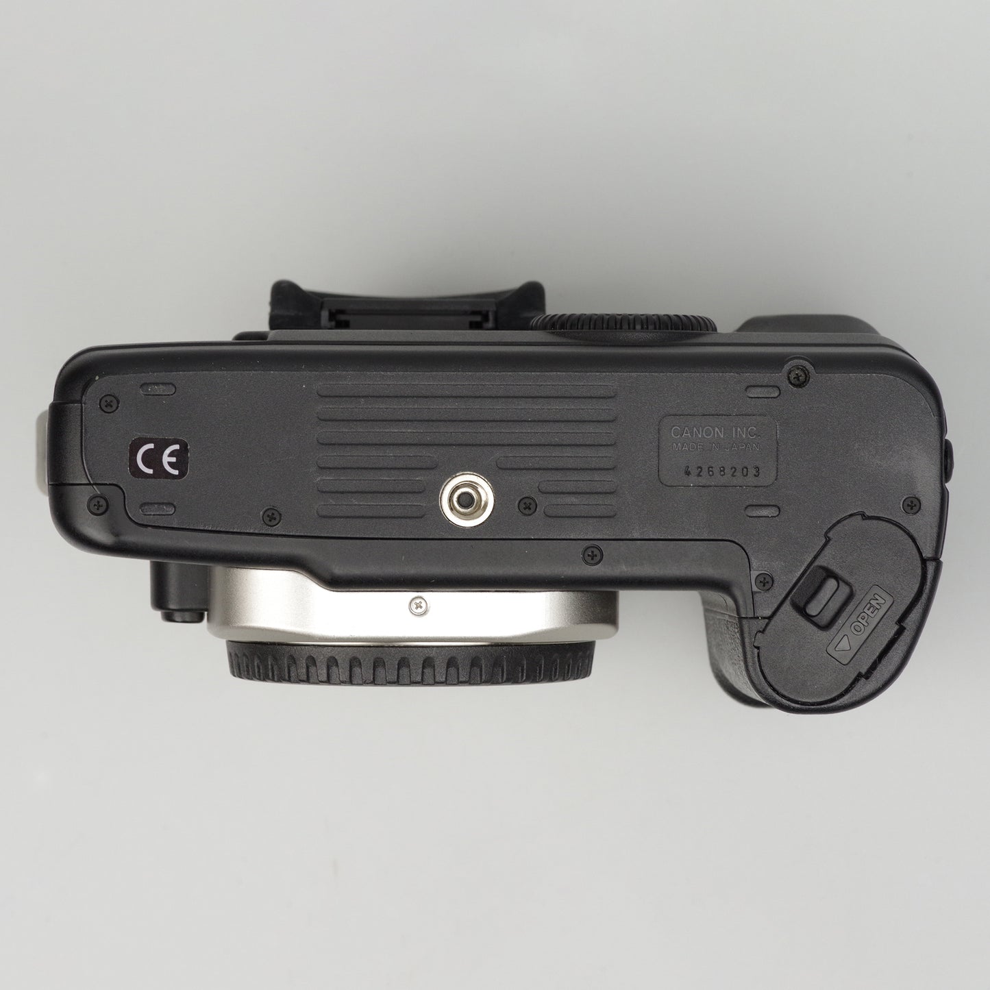 Bottom view of a camera body on a light gray background